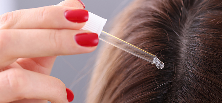 woman-applies-oil-dropper-hair-roots